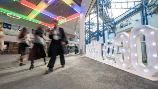 People walking in conference centre, next to large sign reading RCPCH @ 30